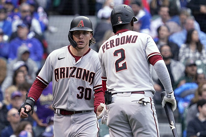 Arizona Diamondbacks' Jake McCarthy, left, celebrates with Geraldo Perdomo after scoring on a single by Alek Thomas during the seventh inning of the team's baseball game against the Chicago Cubs in Chicago, Saturday, May 21, 2022. (Nam Y. Huh/AP)
