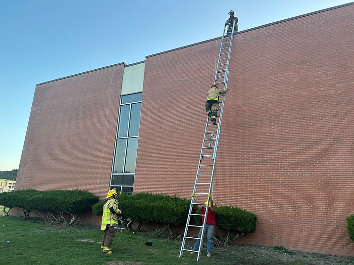 New volunteers with Williams Fire Department receive instruction on tying knots, raising ladders and advancing a hose line to a rooftop during a training exercise May 20 at Williams Elementary-Middle School. (Loretta McKenney/WGCN)