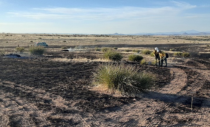 A couple of firefighters work to put out hotspots of a wildfire that started shortly before 5 p.m. on Thursday, May 26, 2022, north of Highway 89A, across from the Prescott Valley water towers. (Tim Wiederaenders/Courier)