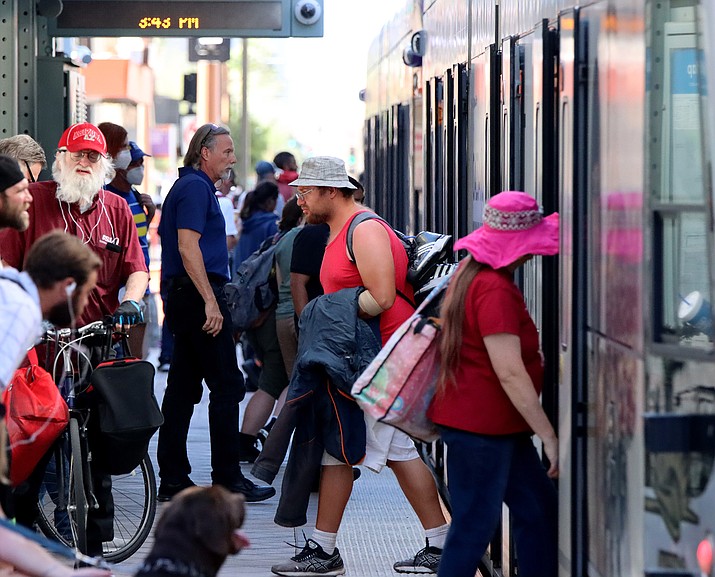 People board the light rail in Phoenix. A new Census Bureau report says that only about 60% of Americans are actually going to work when they go to work, with the rest working virtually. In Arizona, just 58.1% worked on-site as of May. (Chris Nano/Cronkite News)