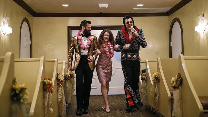 Elvis impersonator Brendan Paul, right, walks down the aisle during a wedding ceremony for Katie Salvatore, center, and Eric Wheeler at the Graceland Wedding Chapel in Las Vegas. Authentic Brands Group (ABG) sent cease-and-desist letters to multiple chapels, saying they had to comply by the end of May, the Las Vegas Review-Journal reported. (John Locher/AP, File)