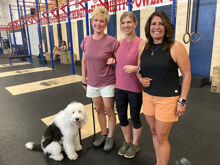 The Prescott threesome of professionals at the Captain CrossFit gym prior to embarking on a 14-day women’s leadership adventure to Tanzania where they will donate two days to an orphanage and women’s center before tackling a seven-day climb to the summit of Mount Kilimanjaro. From left to right: Dr. Jeanette Pilotte and her Sheepadoodle, Dexter;  Captain CrossFit Owner and fitness trainer Michelle Fain and Prescott High School AP computer science, statistics and Freshman Academy teacher Alvina Green. (Nanci Hutson/Courtesy)
