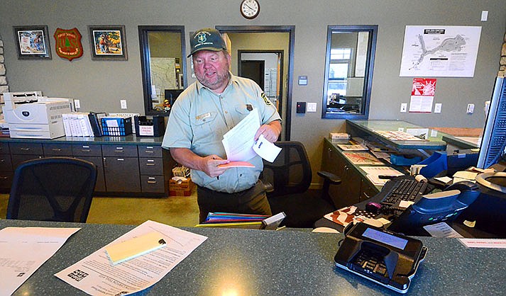 U.S. Forest Service customer service representative Steve Greshman fills out a dead-wood permit at the Verde Ranger District Office,  which reopened its lobby on Monday, June 6, 2022. (VVN/Vyto Starinskas)