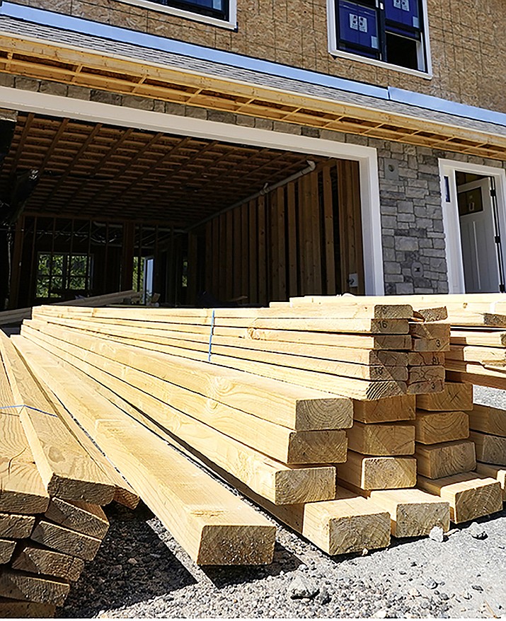 Lumber is piled at a housing construction site. Wood prices have skyrocketed over the past year, leaving would-be home renovators deciding whether to wait out the high costs or move forward on a project that’s more expensive than it would have been a year ago. (Courier file)