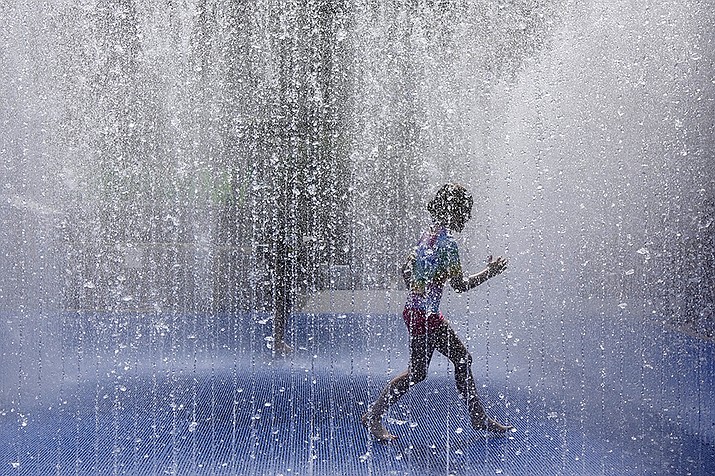 A child plays in a fountain in the warm weather in London, Friday, June 17, 2022. A blanket of hot air stretching from the Mediterranean to the North Sea is giving much of western Europe its first heat wave of the summer, with temperatures forecast to top 30 degrees Celsius (86 degrees Fahrenheit) from Malaga to London on Friday. (Kirsty Wigglesworth/AP)