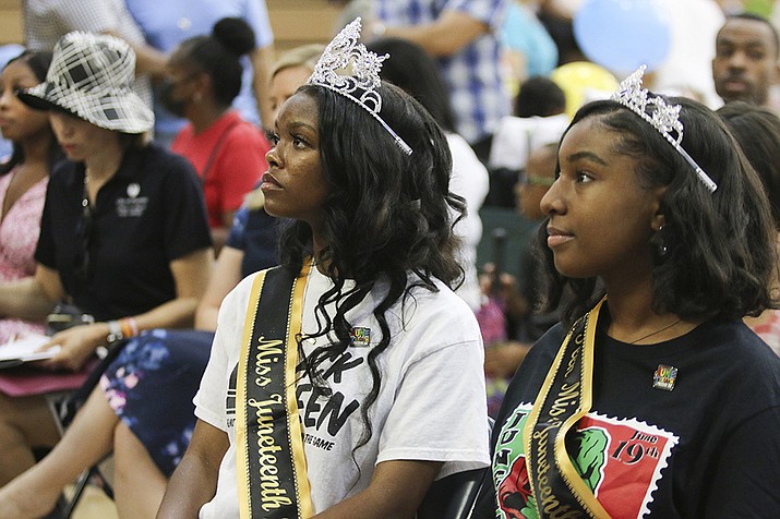 Miss Juneteenth Arizona Shaundrea Norman, 17, left, and Teen Miss Juneteenth Arizona Kendall McCollun, 15, attend an annual Juneteenth celebration at Eastlake Park in Phoenix on Saturday, June 18, 2022. The event featured dozens of businesses, food vendors and educational opportunities for community members. (Cheyanne Mumphrey/AP)