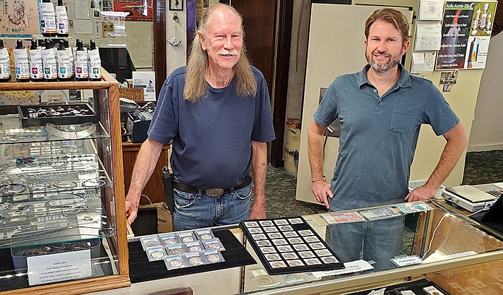 Kim Wright and Gabriel Wright, Coin Heaven co-owners, stand at a display case.