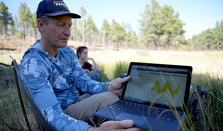 Abe Springer displays a laptop with recorded data from a pressure transducer in a stream fed by Hoxworth Springs, south of Flagstaff on June 15, 2022. (Photo by Troy Hill/Cronkite News)