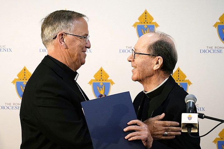 Bishop John Dolan, left, smiles along with retiring Bishop Thomas Olmsted as Dolan is introduced at a news conference after being named the new bishop for the Roman Catholic Diocese of Phoenix Friday, June 10, 2022, in Phoenix. (Ross D. Franklin/AP)