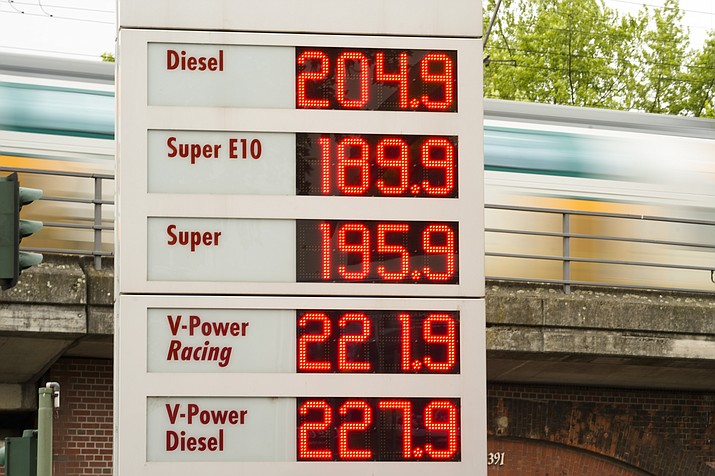 A public transport train drive behind a display with fuel prices at a gas station et in Berlin, Germany, Sunday, June 19, 2022. People across the world are confronted with higher fuel prices as the war in Ukraine and lagging output from producing nations drive prices higher. Drivers are looking at the numbers on the gas pump and rethinking their habits and finances, pushing some to walk, bike or use public transport. (Markus Schreiber/AP)