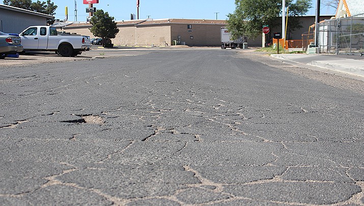 Kingman Streets Superintendent Jack Plaunty briefed Kingman City Council about potential treatments to help fix and maintain paved residential roads. Potholes and cracks are shown on Evans Street. (Photo by MacKenzie Dexter/Kingman Miner)