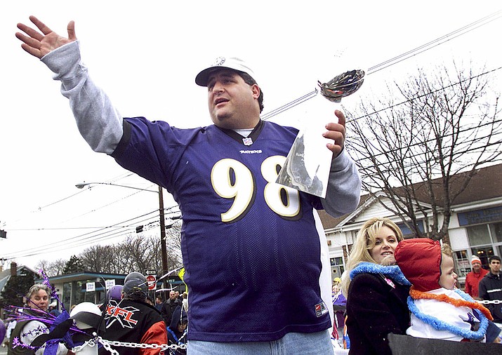 Tony Siragusa, defensive tackle for the Super Bowl-champion Baltimore Ravens, holds the Vince Lombardi trophy as he rides with his wife, Kathy, in a parade in his hometown of Kenilworth, N.J. on March 4, 2001. Siragusa, the charismatic defensive tackle who helped lead a stout Baltimore defense to a Super Bowl title, has died at age 55. Siragusa's broadcast agent, Jim Ornstein, confirmed the death Wednesday, June 22, 2022. (Jeff Zelevansky, AP File)