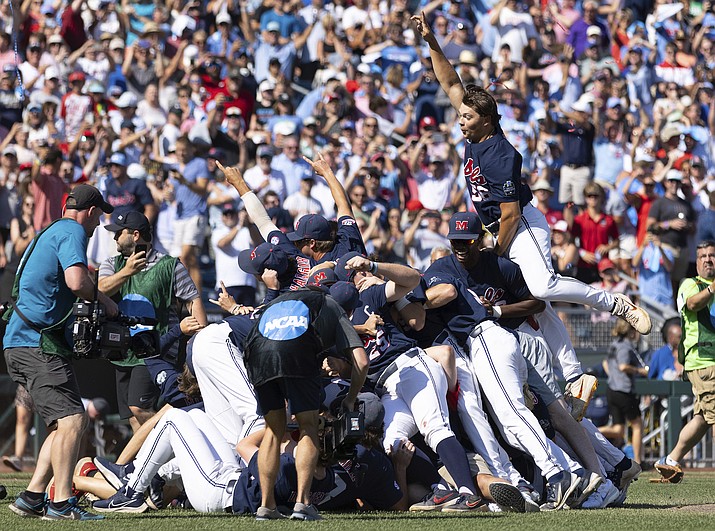 Mississippi's Jack Washburn, right, leaps on top of the team pile in celebration of their 4-2 victory over Oklahoma in Game 2 of the NCAA College World Series baseball finals, Sunday, June 26, 2022, in Omaha, Neb. Mississippi defeated Oklahoma 4-2 to win the championship. (Rebecca S. Gratz/AP)