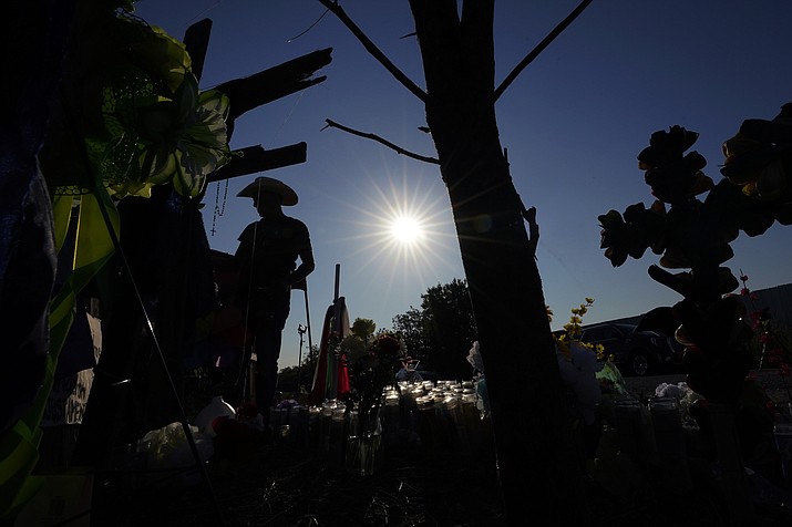 Roberto Marquez adds a cross to a makeshift memorial at the site where officials more than 50 people dead in an abandoned semitrailer containing suspected migrants, Thursday, June 30, 2022, in San Antonio. (Eric Gay/AP)