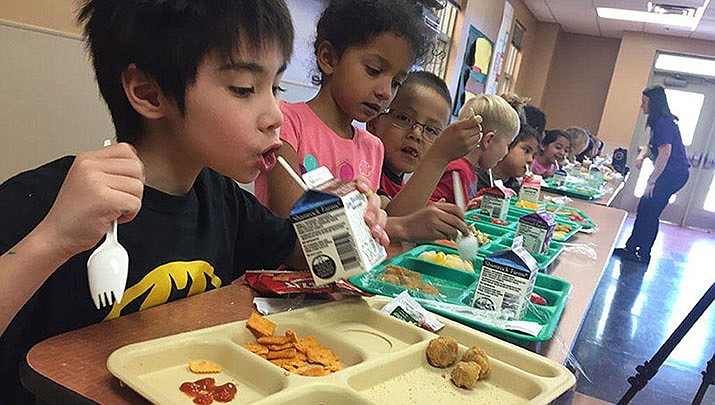 A federal expansion of the school lunch program instituted as a COVID-19 relief measure was set to expire June 30, but will continue through the summer thanks to last-minute congressional action. Students at Barbara Robey Elementary School enjoy lunch in this photo from 2017. (Photo by Lily Altavena/Cronkite News)