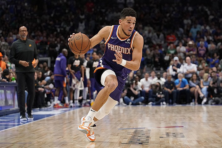 Phoenix Suns guard Devin Booker drives to the basket during Game 3 of an NBA basketball second-round playoff series against the Dallas Mavericks, May 7, 2022, in Dallas. Booker agreed to a four-year contract extension early Friday, July 1. (AP Photo/Tony Gutierrez, File)