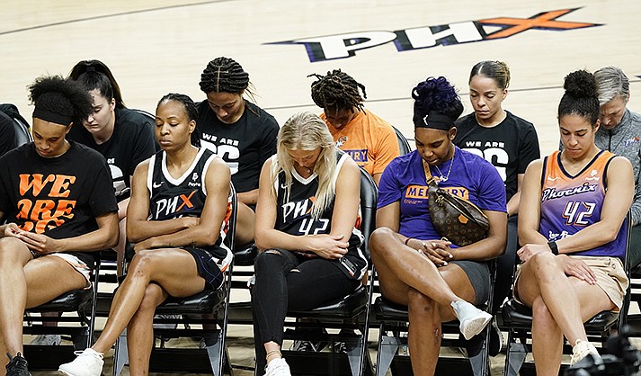 Phoenix Mercury players bow their heads in prayer at a rally for WNBA basketball teammate Brittney Griner Wednesday, July 6, 2022, in Phoenix. Griner has been detained in Russia for 133 days, charged in Russia for having vape cartridges containing hashish oil in her luggage. (AP Photo/Ross D. Franklin)