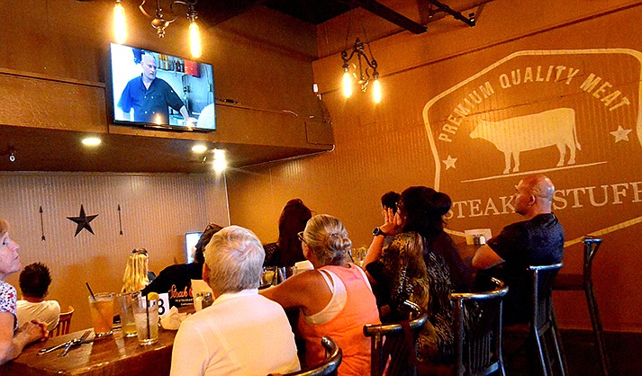 People watch the Restaurant Impossible show on Thursday, July 7, 2022, inside Steak N Stuff in Cottonwood. (VVN/Vyto Starinskas)