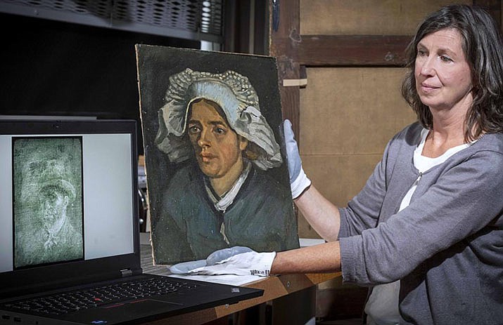 Senior Conservator Lesley Stevenson views "Head of a Peasant Woman" alongside an X-ray image of the hidden Van Gogh self-portrait. The National Galleries of Scotland said Thursday the self-portrait was discovered when experts took an X-Ray of the canvas ahead of an upcoming exhibition. (Neil Hanna via AP)