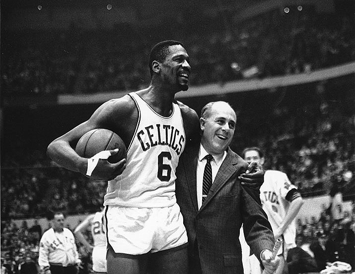 Bill Russell, left, star of the Boston Celtics is congratulated by coach Arnold "Red" Auerbach after scoring his 10,000th point in the NBA game against the Baltimore Bullets in Boston Garden on Dec. 12, 1964. (Bill Chaplis/AP, file)