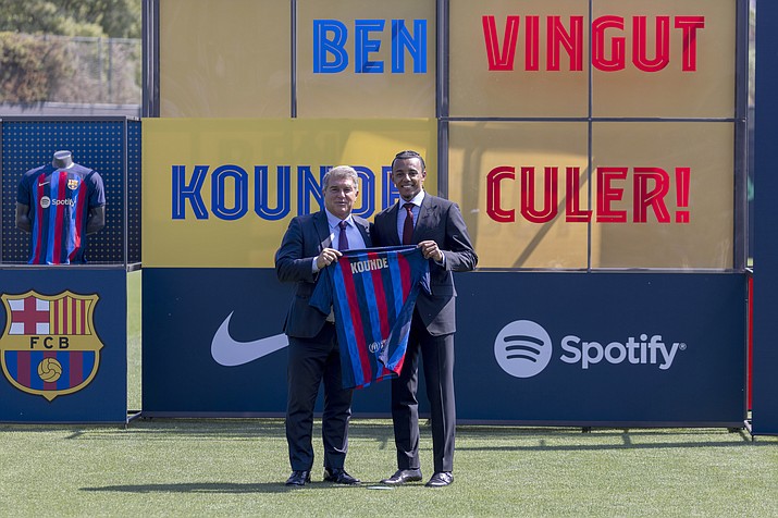 French defender Jules Kounde, right, poses with FC Barcelona president Joan Laporta during his official presentation after signing for FC Barcelona in Barcelona, Spain, Monday, Aug. 1, 2022. (Joan Monfort/AP)