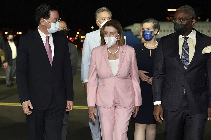 U.S. House Speaker Nancy Pelosi, center, walks with Taiwan's Foreign Minister Joseph Wu, left, as she arrives in Taipei, Taiwan, Tuesday, Aug. 2, 2022. Pelosi arrived in Taiwan on Tuesday night despite threats from Beijing of serious consequences, becoming the highest-ranking American official to visit the self-ruled island claimed by China in 25 years. (Taiwan Ministry of Foreign Affairs via AP)