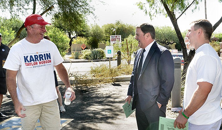 Gov. Doug Ducey, center, and son Joe, both with early ballots in hand, chat Tuesday with Andy Kunasek outside their polling place in Paradise Valley. Kunasek was a volunteer for his sister, Karrin Taylor Robson, in her bid to be the Republican nominee for governor. (Capitol Media Services photo by Howard Fischer)