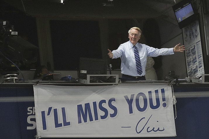 Los Angeles Dodgers broadcaster Vin Scully gestures in his booth during a game between the Los Angeles Dodgers and the Colorado Rockies, Sept. 23, 2016, in Los Angeles, two days before his final game from Dodger Stadium. Scully, whose dulcet tones provided the soundtrack of summer while entertaining and informing Dodgers fans in Brooklyn and Los Angeles for 67 years, died Tuesday night, Aug. 2, 2022, the team said. He was 94. (Jae C. Hong/AP, File)