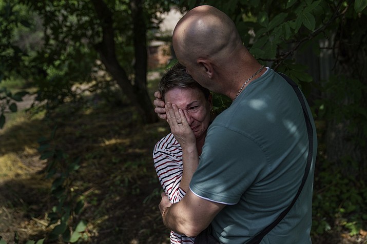 Marina Havrysh, left, is comforted by her husband, Vadim, as she weeps while watching her elderly parents helped into a van to be evacuated to a safer part of the country in the west from their home in Kramatorsk, Donetsk region, eastern Ukraine, Tuesday, Aug. 2, 2022. "I understand that this will be the last time I ever see them," she said. "You see their age, I can't give them the proper care." (David Goldman/AP)