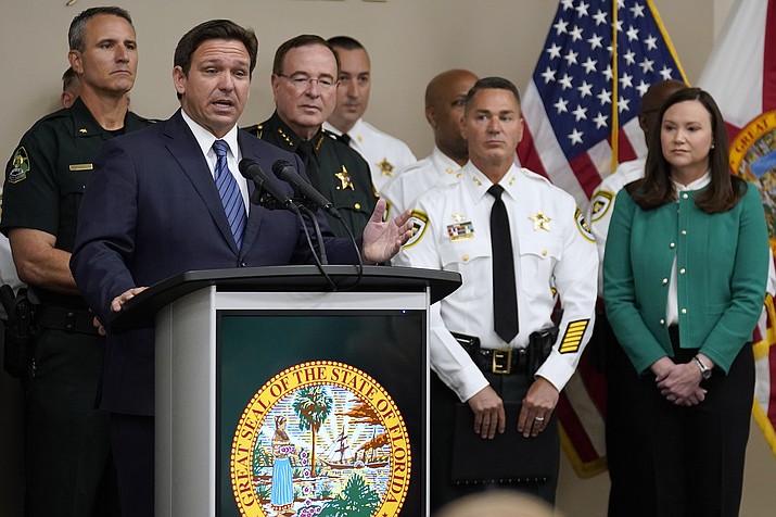 Florida Gov. Ron DeSantis, surrounded by members of law enforcement, gestures as he speaks during a news conference Thursday, Aug. 4, 2022, in Tampa, Fla. DeSantis announced that he was suspending State Attorney Andrew Warren, of the 13th Judicial Circuit, due to "neglect of duty." Looking on at right is Florida Attorney General Ashley Moody. (Chris O'Meara/AP)