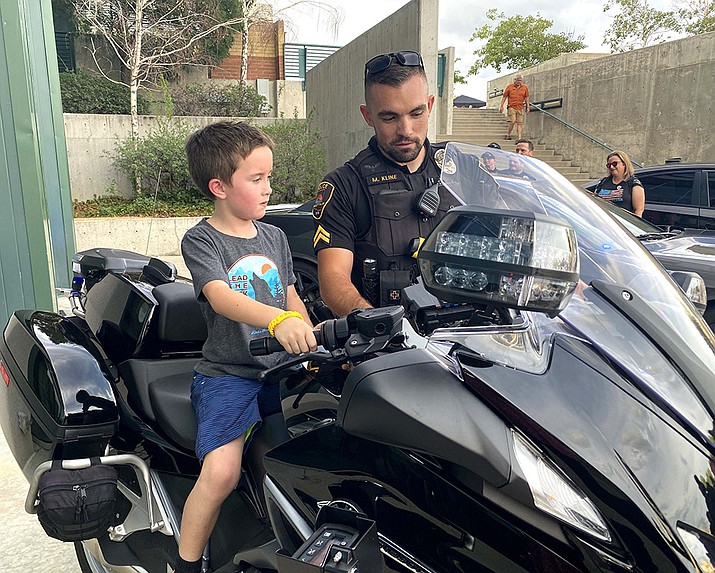 Prescott Valley Police Department officer Matt Kline shows off the department’s 
new traffic motorcycle to a young visitor at the National Night Out event held at the Prescott Valley Civic Center Aug. 2, 2022. For a photo gallery of the event, visit dCourier.com. (Town of Prescott Valley/Courtesy)