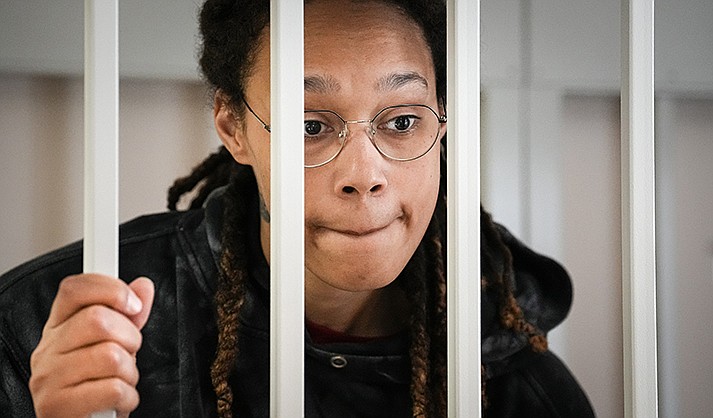 WNBA star and two-time Olympic gold medalist Brittney Griner speaks to her lawyers standing in a cage at a court room prior to a hearing, in Khimki just outside Moscow, Russia, July 26, 2022. American basketball star Brittney Griner returned Tuesday to a Russian courtroom for her drawn-out trial on drug charges that could bring her 10 years in prison of convicted. (AP Photo/Alexander Zemlianichenko, Pool)