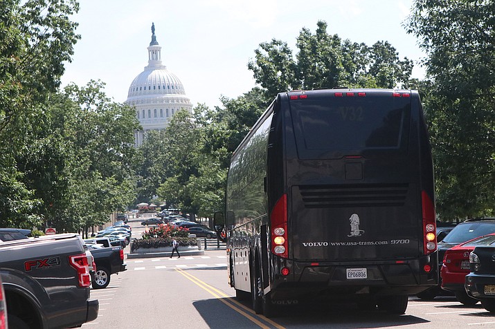 A bus that carried migrants from the border to Washington, D.C., idles near Union Station, just two blocks from the U.S. Capitol. The trips, paid for by Texas and Arizona, are straining local resources, D.C. officials said. (Daisy Gonzalez-Perez/Cronkite News)
