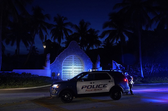 Police stand outside an entrance to former President Donald Trump's Mar-a-Lago estate, Monday, Aug. 8, 2022, in Palm Beach, Fla. Trump said in a lengthy statement that the FBI was conducting a search of his Mar-a-Lago estate and asserted that agents had broken open a safe. (Wilfredo Lee/AP)