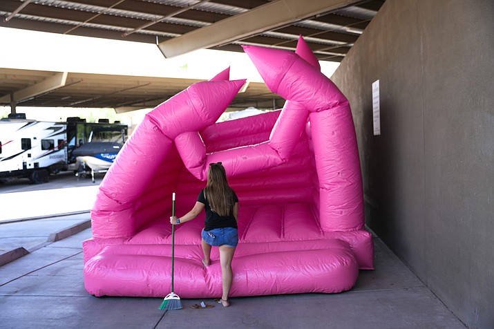 Allie Dziewulski waits to clean a bounce house as it inflates at Jump Into Bliss’ storage facility in Goodyear on June 10, 2022. The business began to take off in January 2021 after one of its TikTok videos went viral. (Troy Hill/Cronkite News)