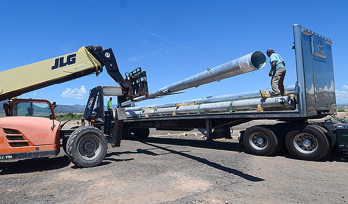 Crews unload poles for new sports lighting at the Camp Verde Sports Complex Monday, Aug. 8, 2022. Backups at APS are affecting the pace of the project. (VVN/Vyto Starinskas)
