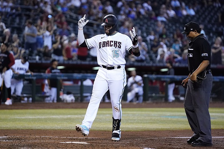 Arizona D-backs’ Emmanuel Rivera (15) celebrates as he arrives at home plate on his home run as umpire Erich Bacchus, right, looks on during the fourth inning of a game Thursday, Aug. 11, 2022, in Phoenix. (Ross D. Franklin/AP)