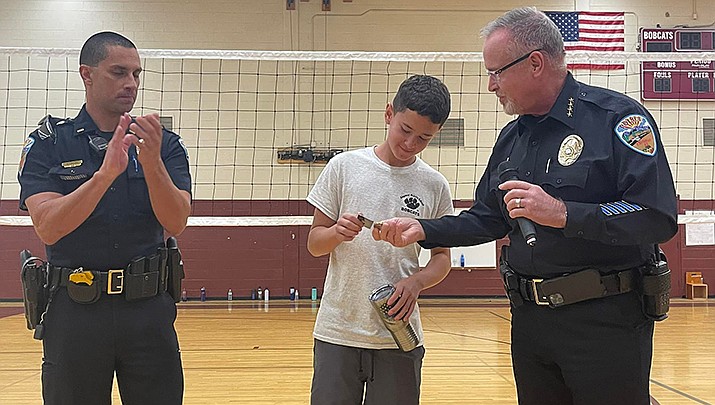 Kingman Middle School eighth-grader Levi Cortez receives an award from Kingman Police Department Chief Rusty Cooper after helping a lost boy get to safety. (Courtesy photo)