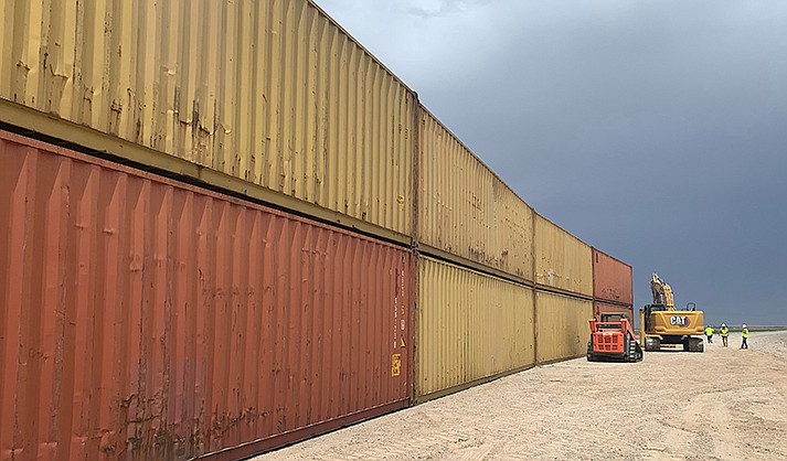 This photo provided by the Arizona Governor's Office shows shipping containers that will be used to fill a 1,000 foot gap in the border wall with Mexico near Yuma, Ariz., on Friday, Aug. 12, 2022. Two will be stacked atop each other and then topped with razor wire to slow migrants from crossing into Arizona. Republican Gov. Doug Ducey acted without federal permission and plans to fill three gaps totaling 3,000 feet in the coming weeks. (Arizona Governor's Office via AP)