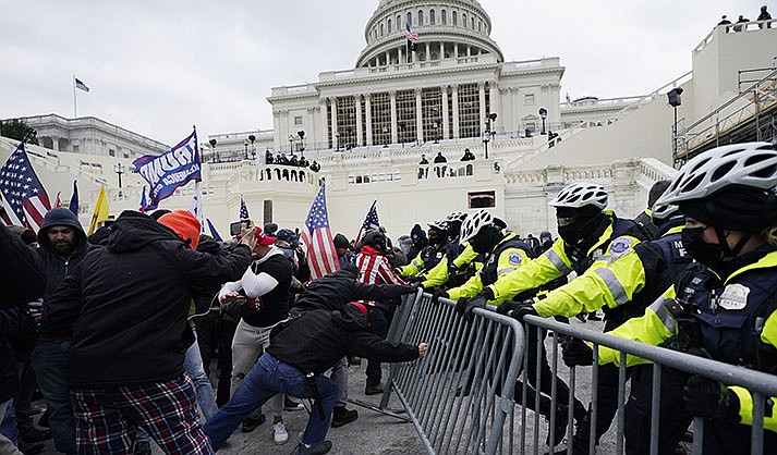 Insurrectionists loyal to President Donald Trump try to break through a police barrier, Wednesday, Jan. 6, 2021, at the Capitol in Washington. Facing prison time and dire personal consequences for storming the U.S. Capitol, some Jan. 6 defendants are trying to profit from their participation in the deadly riot, using it as a platform to drum up cash, promote business endeavors and boost social media profiles. (AP Photo/Julio Cortez, File)