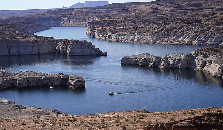 A boat cruises along Lake Powell near Page on July 31, 2021. Seven states in the U.S. West are facing a deadline from the federal government to come up with a plan to use substantially less Colorado River water in 2023. (AP Photo/Rick Bowmer, File)