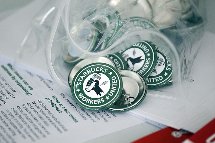 Pro-union pins sit on a table during a watch party for Starbucks' employees union election, Dec. 9, 2021, in Buffalo, N.Y. Starbucks is asking the National Labor Relations Board to temporarily suspend all union elections at its U.S. stores in response to allegations of improper coordination between regional NLRB officials and the union. (Joshua Bessex/AP, File)