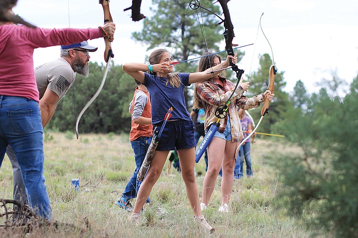 Mentor John Sparlin coaches Ara Deane, 11, as she aims for her target at the Parks in the Pines 4H archery shoot July 30.  Deane was joined by her siblings Cora, 13, and Wesley, 8, who are part of the Shamrock 4H in Prescott, Arizona. (Wendy Howell/WGCN)