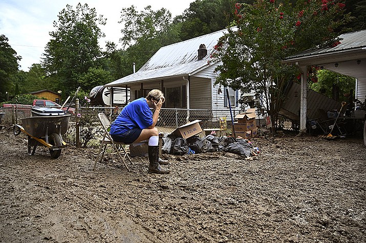 Teresa Reynolds sits exhausted as members of her community clean the debris from their flood ravaged homes at Ogden Hollar in Hindman, Ky., July 30, 2022. This summer the weather has not only been extreme, but it has whiplashed from one extreme to another. Dallas, St. Louis, Kentucky, Yellowstone, Death Valley all lurched from drought to flood. (Timothy D. Easley/AP, File)