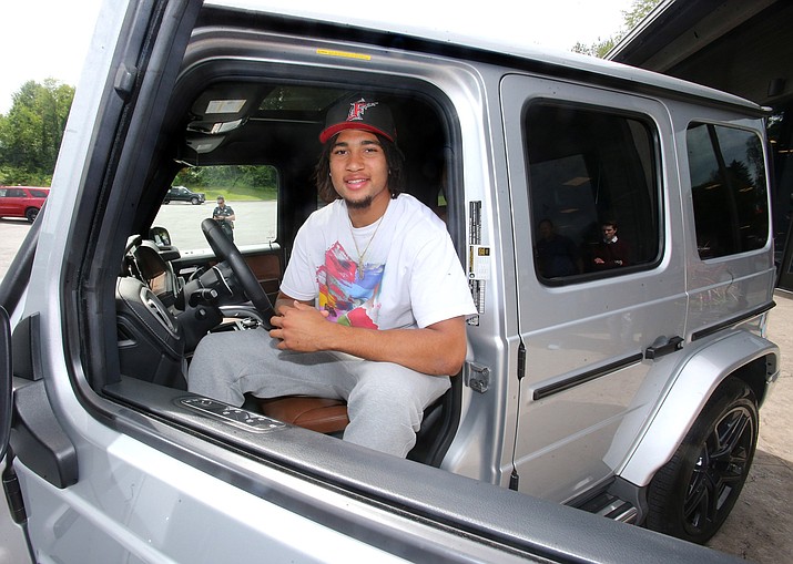 Ohio State quarterback C.J. Stroud sits in the drivers seat after he received a 2019 Mercedes G-Wagon G63 in Canton, Ohio on June 8, 2022. Stroud has a deal with Sarchione Auto Gallery that allows them to use the quarterback's name, image and likeness in its advertising. Glance around the parking lot of the Woody Hayes Athletic Center at The Ohio State University this fall and you might come across a $200,000 palace on wheels, the kind of luxury ride more likely to be found in the garages of movie stars, music moguls and titans of business than on a college campus. (The Repository/Scott Heckel via AP)