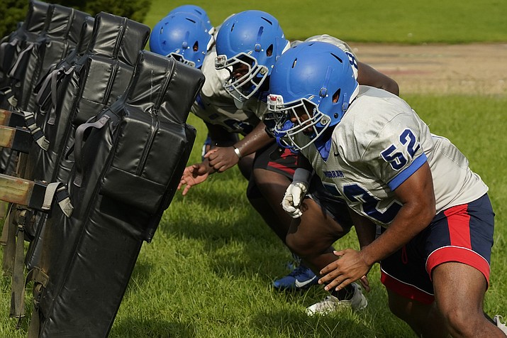 Murrah High School football offensive linemen square up against the blocking sled at practice, Wednesday, Aug. 31, 2022, in Jackson, Miss. The city's low water pressure concerns football coach Marcus Gibson, as it limits his options for washing practice uniforms, towels and other gear his players wear. The recent flood worsened Jackson's longstanding water system problems. (Rogelio V. Solis/AP)