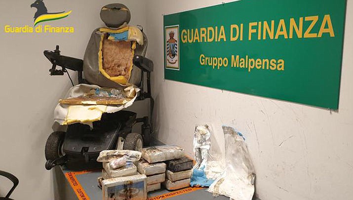 This picture made available Friday, Sep. 2, 2022, by the Italian Financial Police shows the motorized wheelchair used by a man who tried to smuggle some nearly 30 pounds of cocaine, foreground, at Milan airport, northern Italy. Police said that when the cocaine was found, the chair user, a Spaniard who had requested airport personnel to help guide the wheelchair, got up, walked without assistance, and was taken into custody. (Guardia di Finanza via AP)