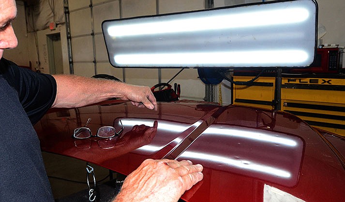 David Upham pushes out hail damage dents at Vince’s Auto Body shop on Friday Sept. 9, 2022, on a hood of a 2019 Ford pickup with an aluminum body damaged in the Aug. 23 storm in Cottonwood. (VVN/Vyto Starinskas)