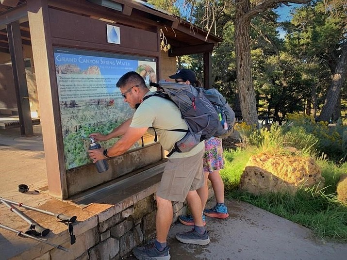 Hikers fill water bottles at the Bright Angel Trailhead before heading down trail. (NPS Photo)