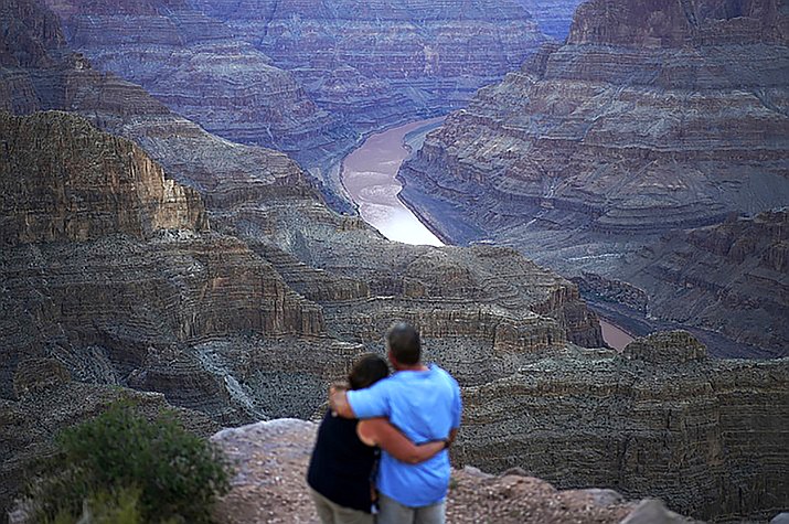 Alyssa Chubbuck, left, and Dan Bennett embrace while watching the sunset at Guano Point overlooking the Colorado River on the Hualapai reservation Monday, Aug. 15, 2022, in northwestern Arizona.  (John Locher/AP)